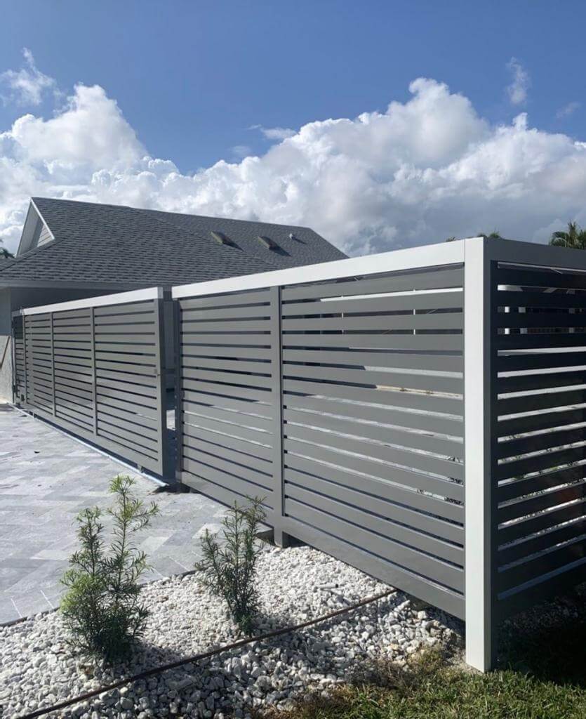 Grey horizontal slat fence with paver walkway and plants - Solaris Garden